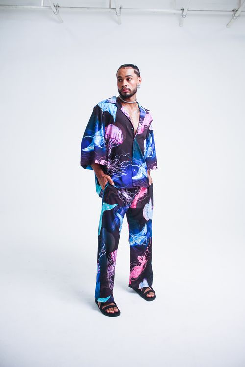 Free Trendy young man wearing colorful artistic outfit, looking confidently to the side in studio. Stock Photo
