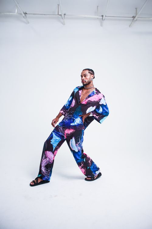 Free Stylish man in vibrant patterned jumpsuit posing creatively indoors. Stock Photo