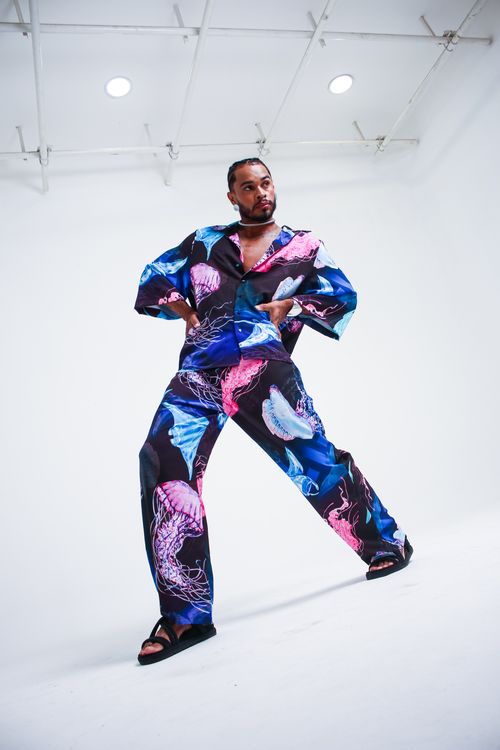 Free Stylish man in vibrant jellyfish print suit striking a pose in a modern studio setting. Stock Photo