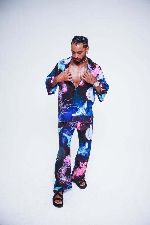 Free Fashionably dressed man poses confidently in colorful attire against a plain white backdrop. Stock Photo