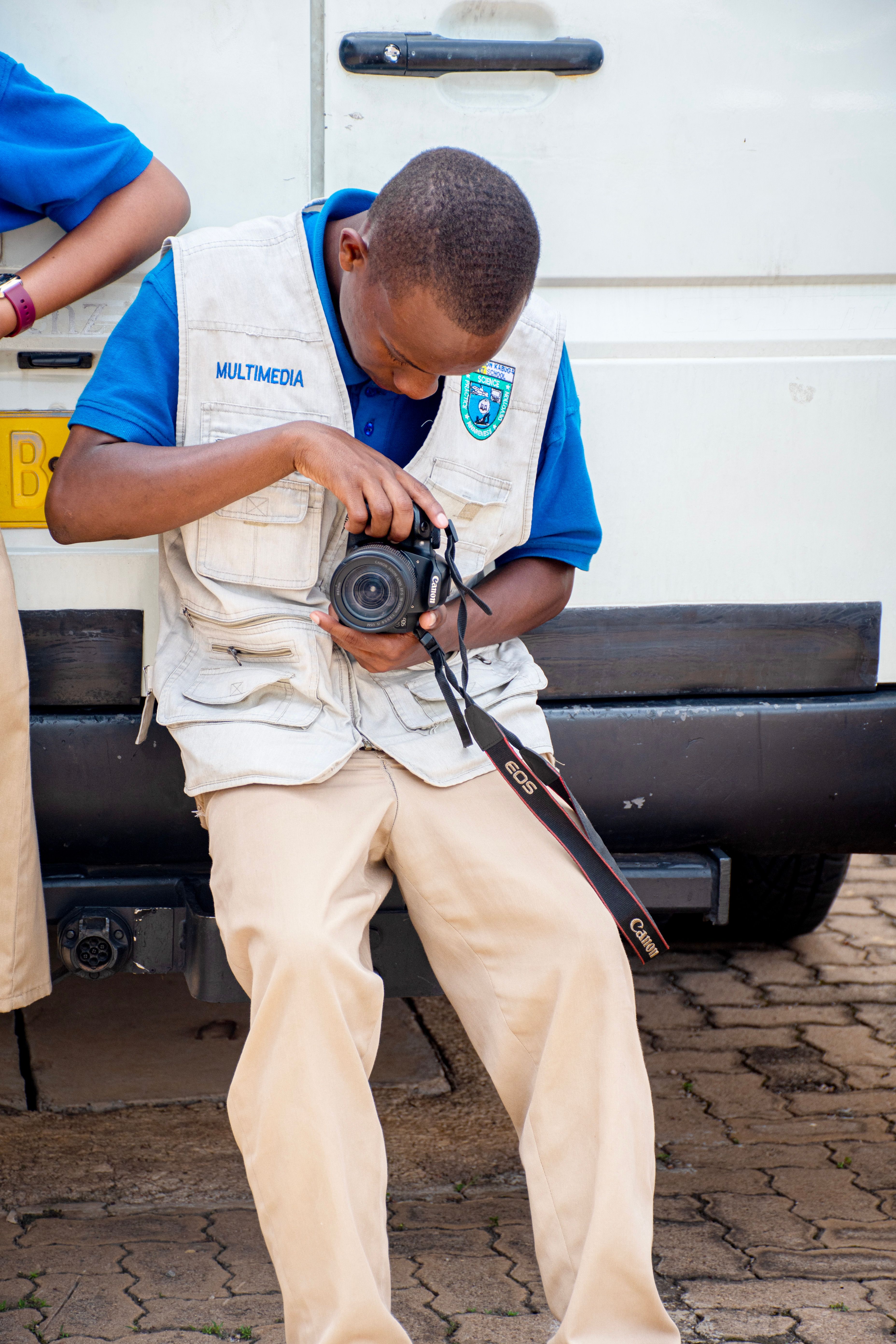 A photographer examines his camera shots while sitting outdoors in Rwanda.