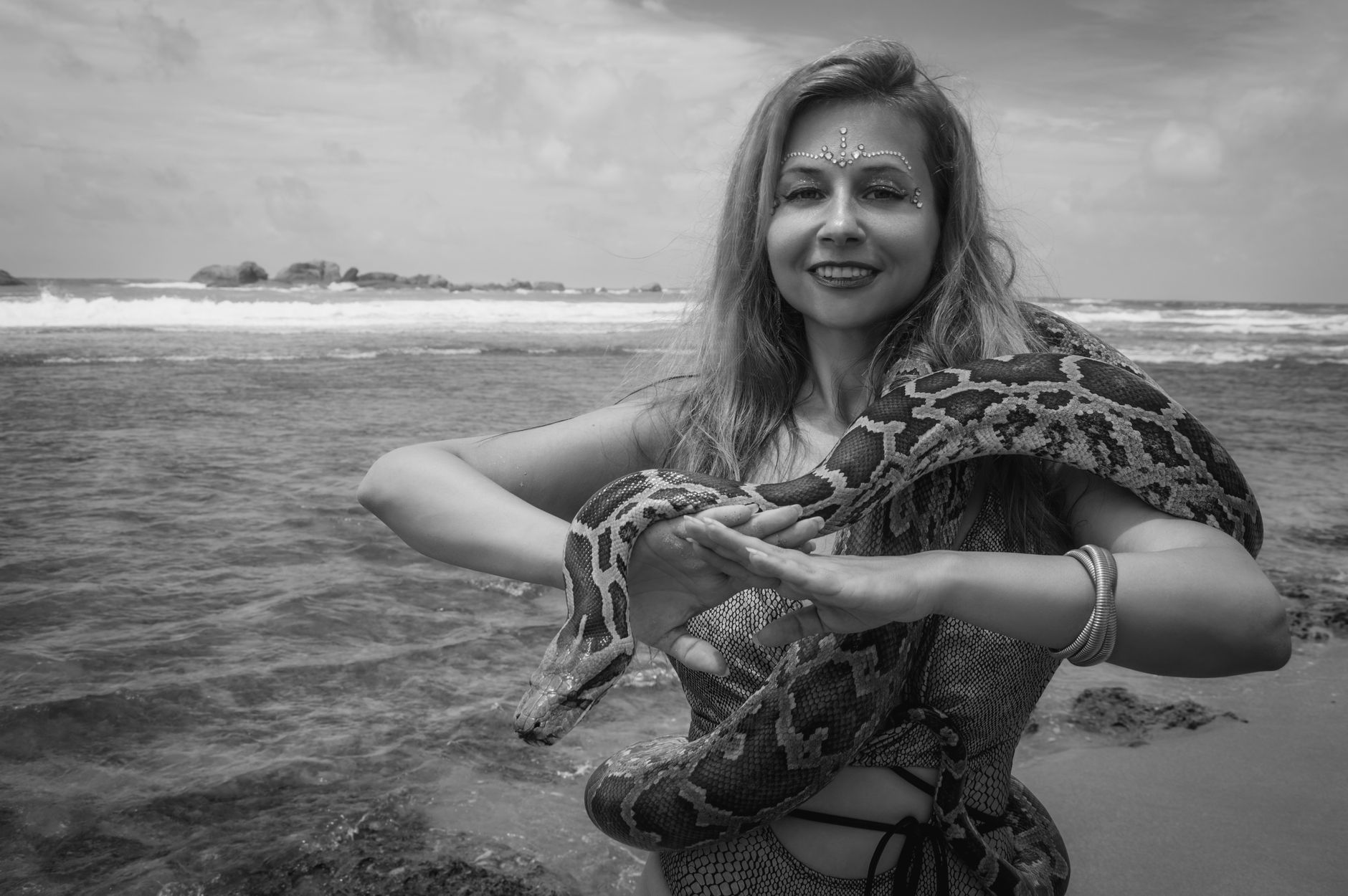 Young woman confidently displaying snake tattoo on wrist at outdoor lifestyle setting