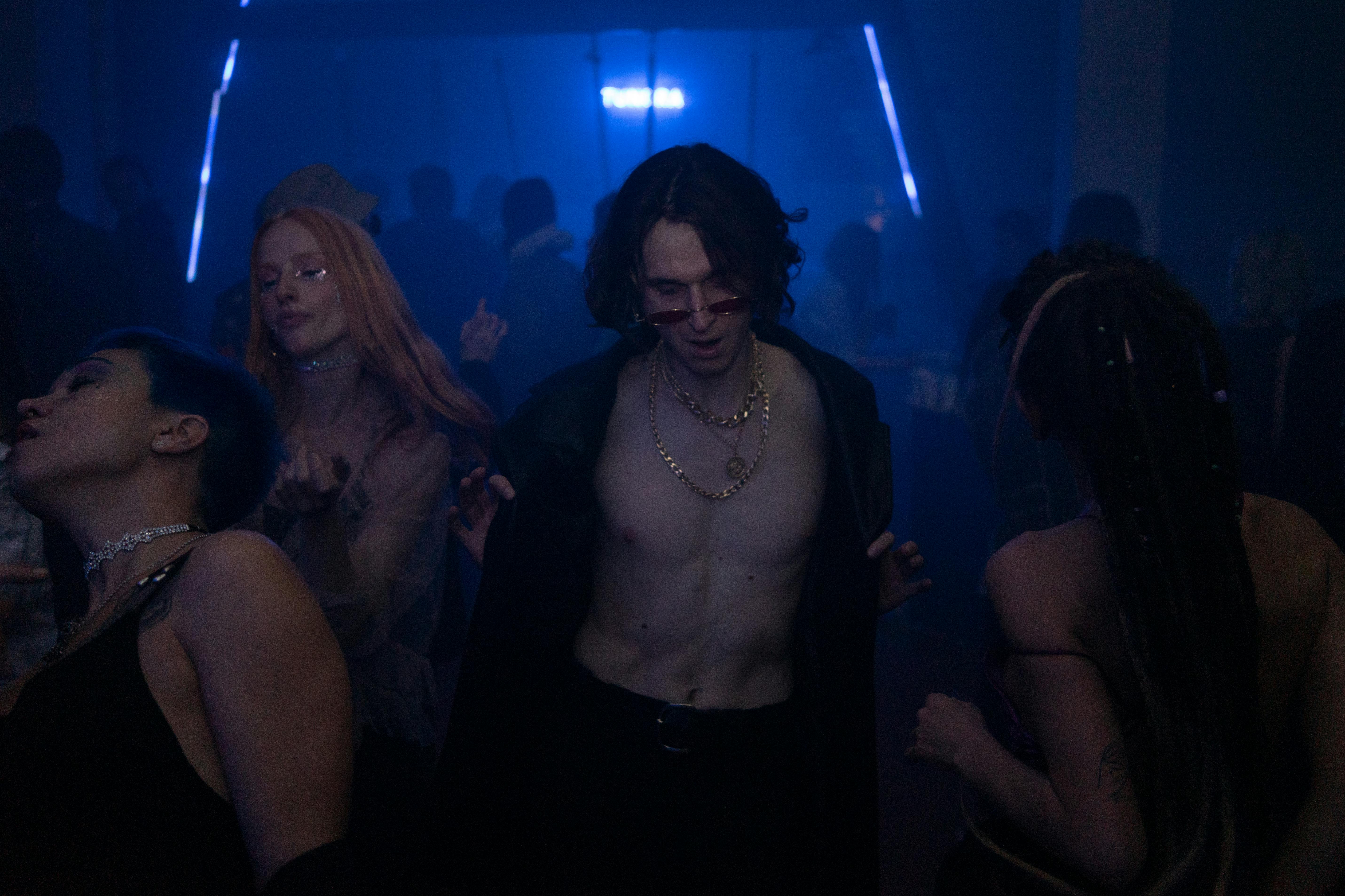 Close-up of a man wearing a gold chain at collarbone length.