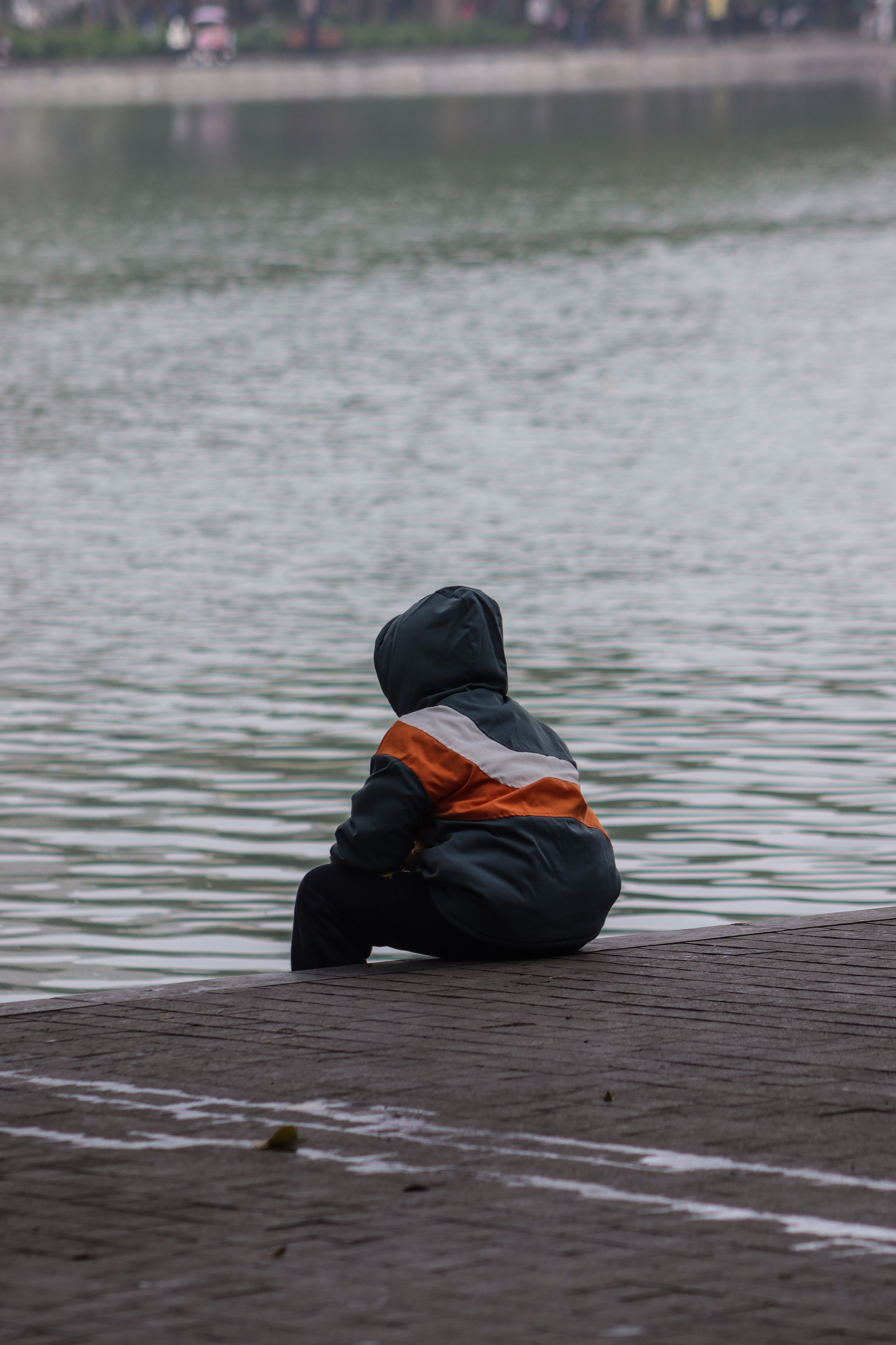 Contemplative Child by a Calm Lake · Free Stock Photo