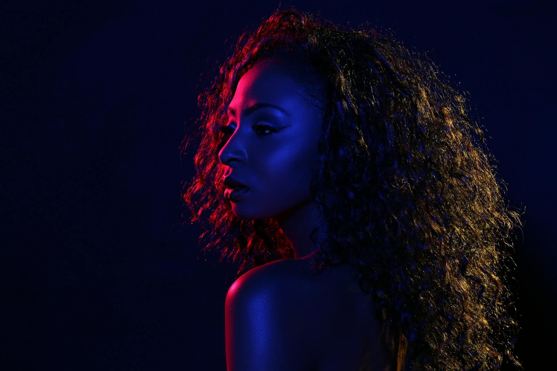 Portrait Photo of Woman in Blue and Red Light Background Posing