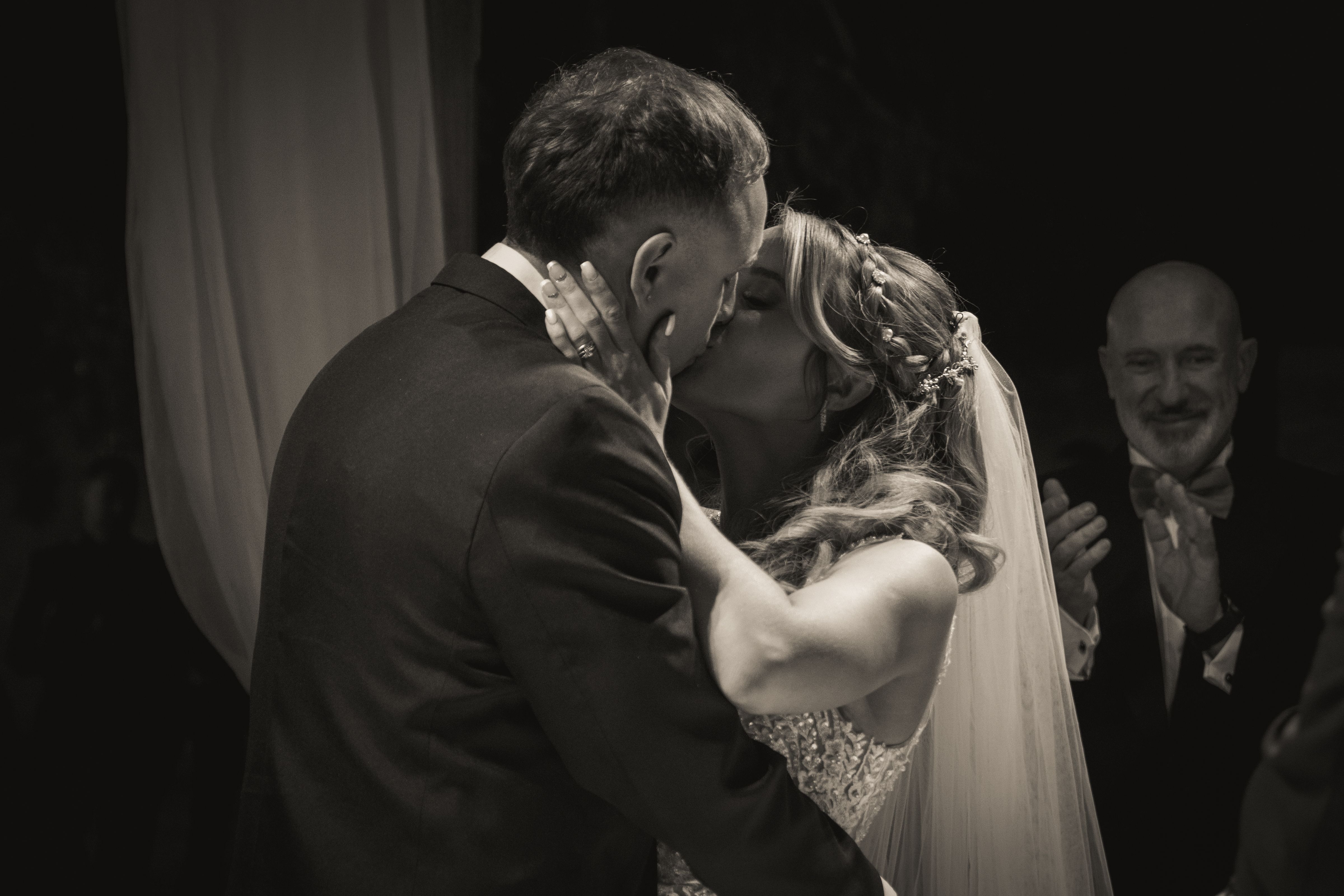 Bride and groom sharing their first kiss at the ceremony