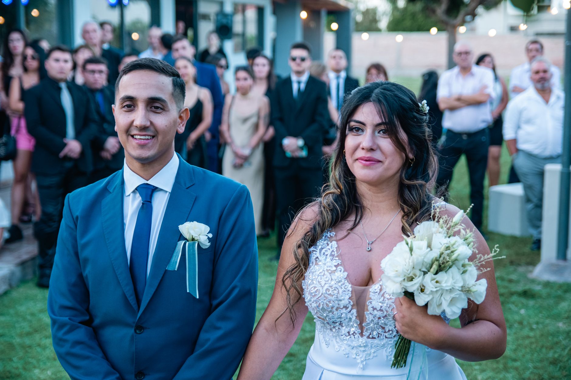 zaffa band for wedding cairo — Happy couple during an outdoor wedding ceremony surrounded by guests.
