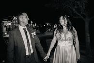 A joyful couple celebrates their wedding, captured in a black and white photo under evening lights.