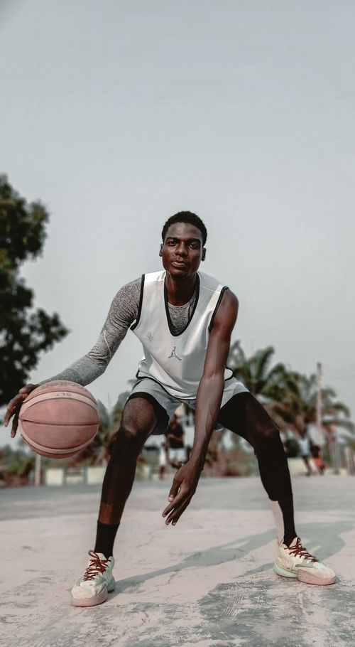 Free A young male basketball player dribbling on an outdoor court in Moro, Nigeria. Stock Photo