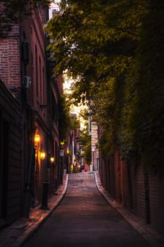 Charming Boston alley with brick buildings and warm lighting, evoking a cozy and serene atmosphere.