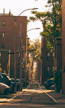 A serene Boston city street bathed in golden hour light, capturing urban architecture and tranquility.