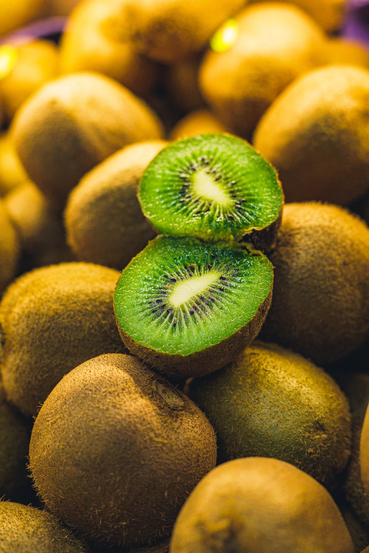 Kiwis maduros, incluindo um fruto cortado ao meio