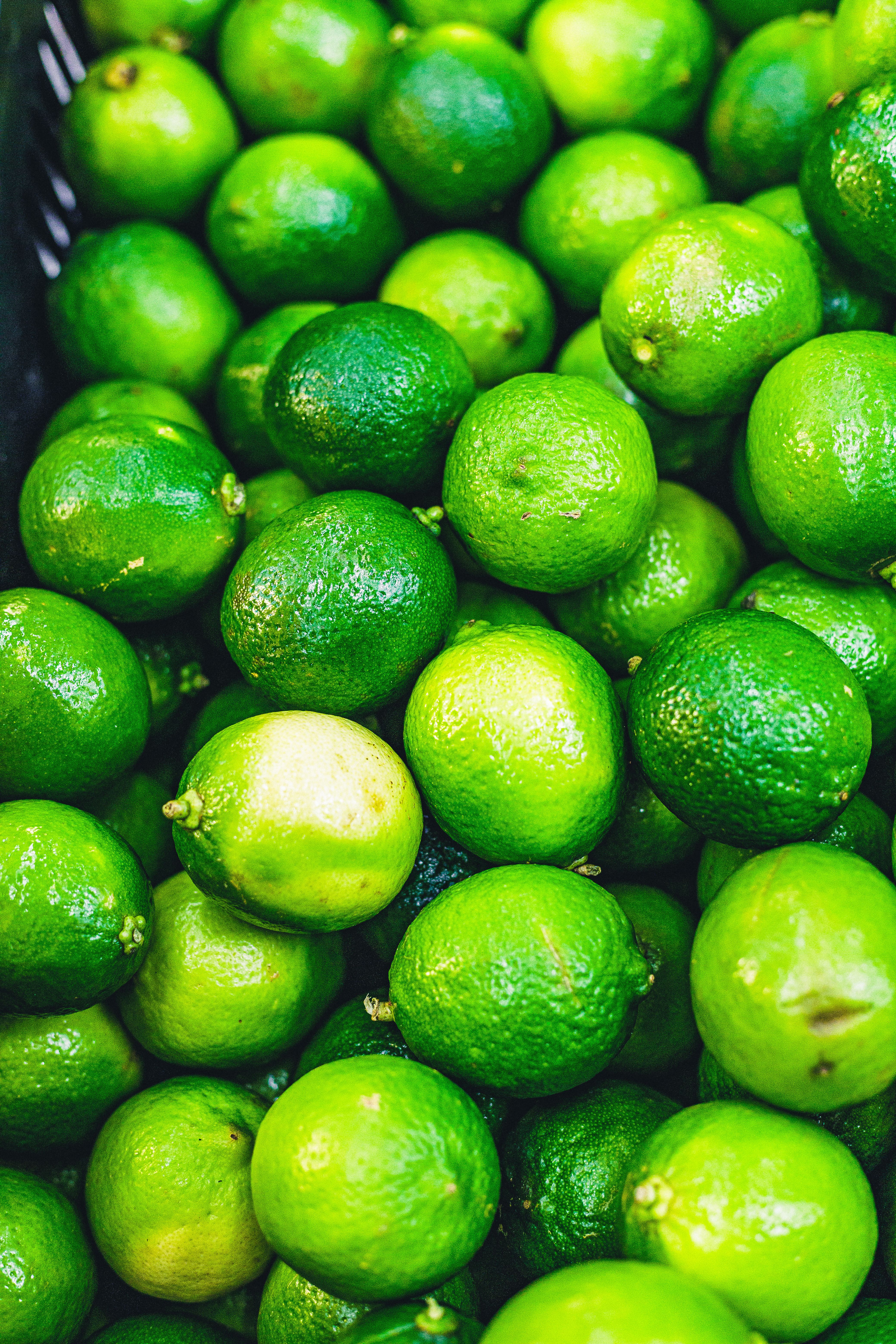 A collection of fresh green limes on display, offering a vibrant and refreshing feel.