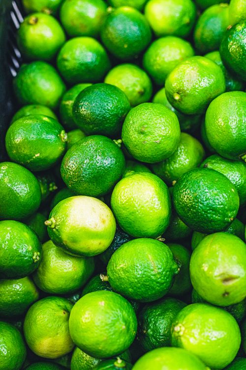 Free A collection of fresh green limes on display, offering a vibrant and refreshing feel. Stock Photo
