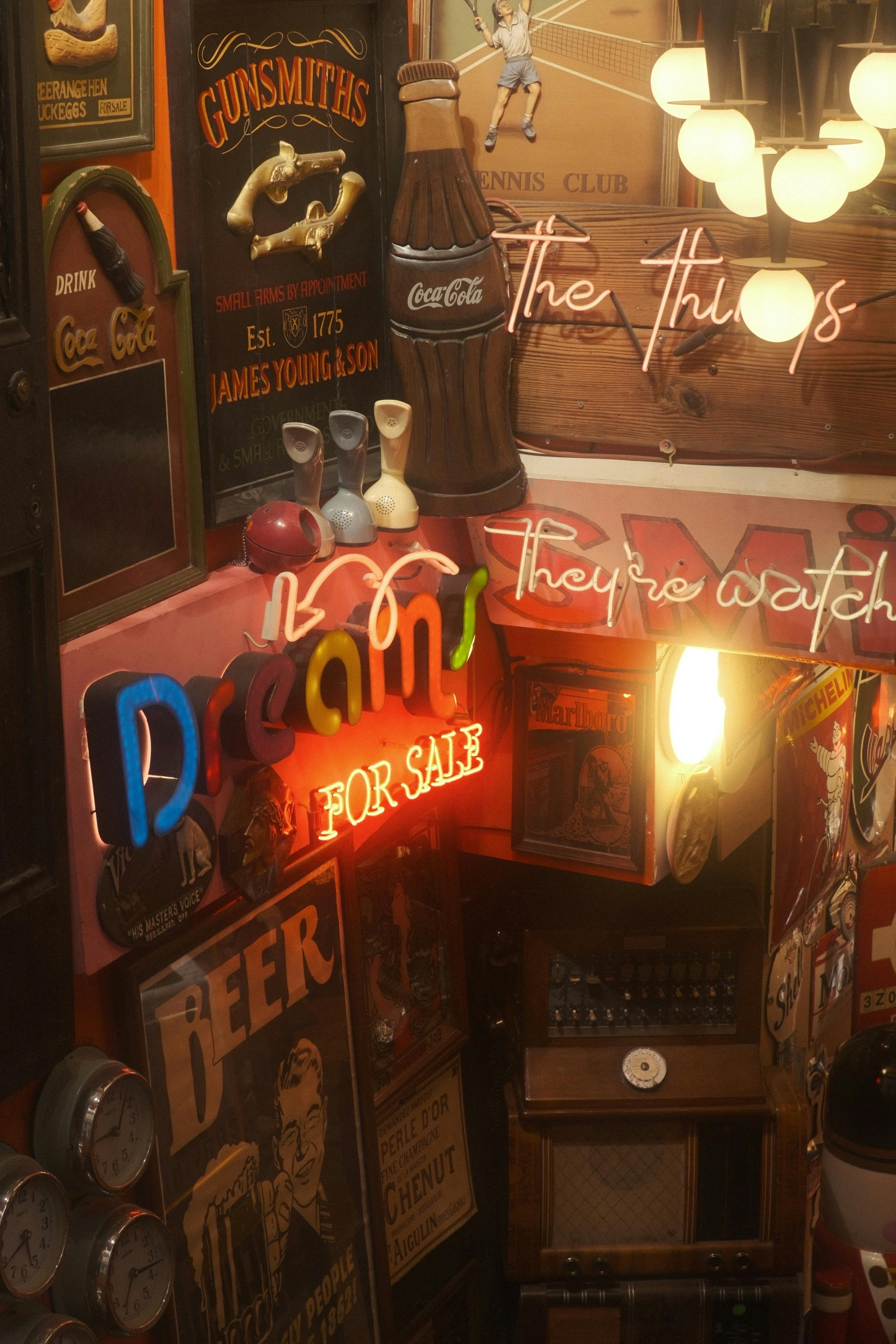 Vintage décor in a cozy space with eclectic neon signs and retro posters.