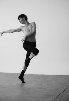 Black and white photo of a male dancer captured mid-movement, exuding grace and strength.
