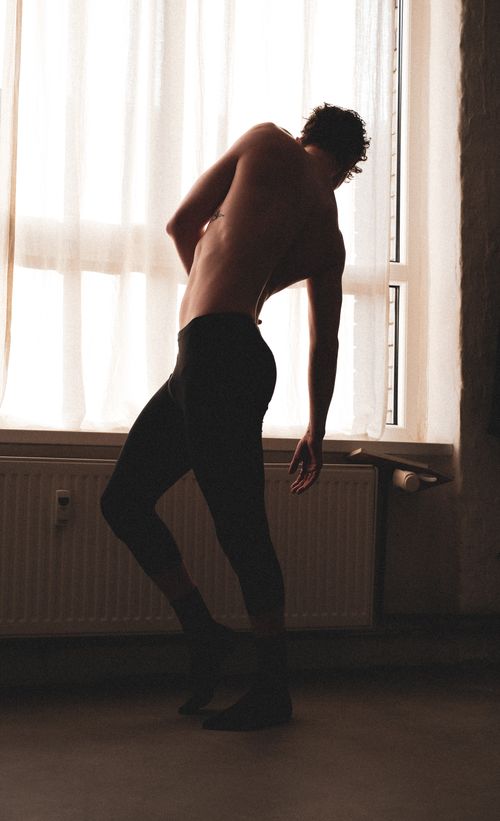 Free Artistic silhouette of a dancer posing by a backlit window, conveying grace and elegance. Stock Photo