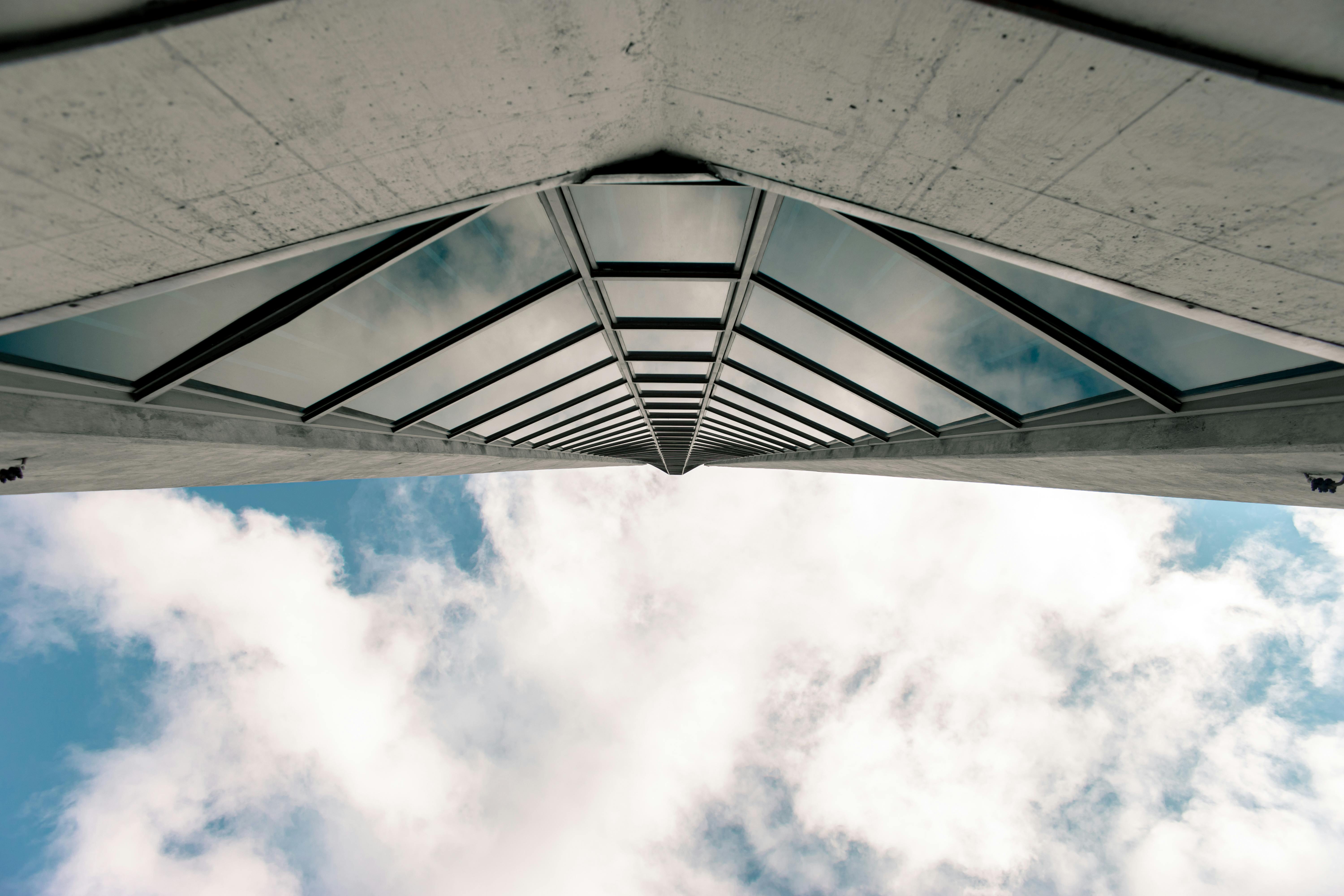 低角度镜头捕捉了一栋摩天大楼，其窗户反射着天空中的云层