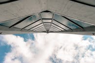 低角度镜头捕捉了一栋摩天大楼，其窗户反射着天空中的云层