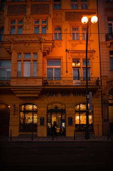 Evening view of the ornate Cafe Bar Riviera facade in Prague, capturing its warm ambiance.