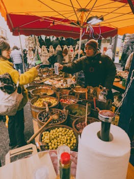 Colorful market scene with fresh olives and spices displayed outdoors.