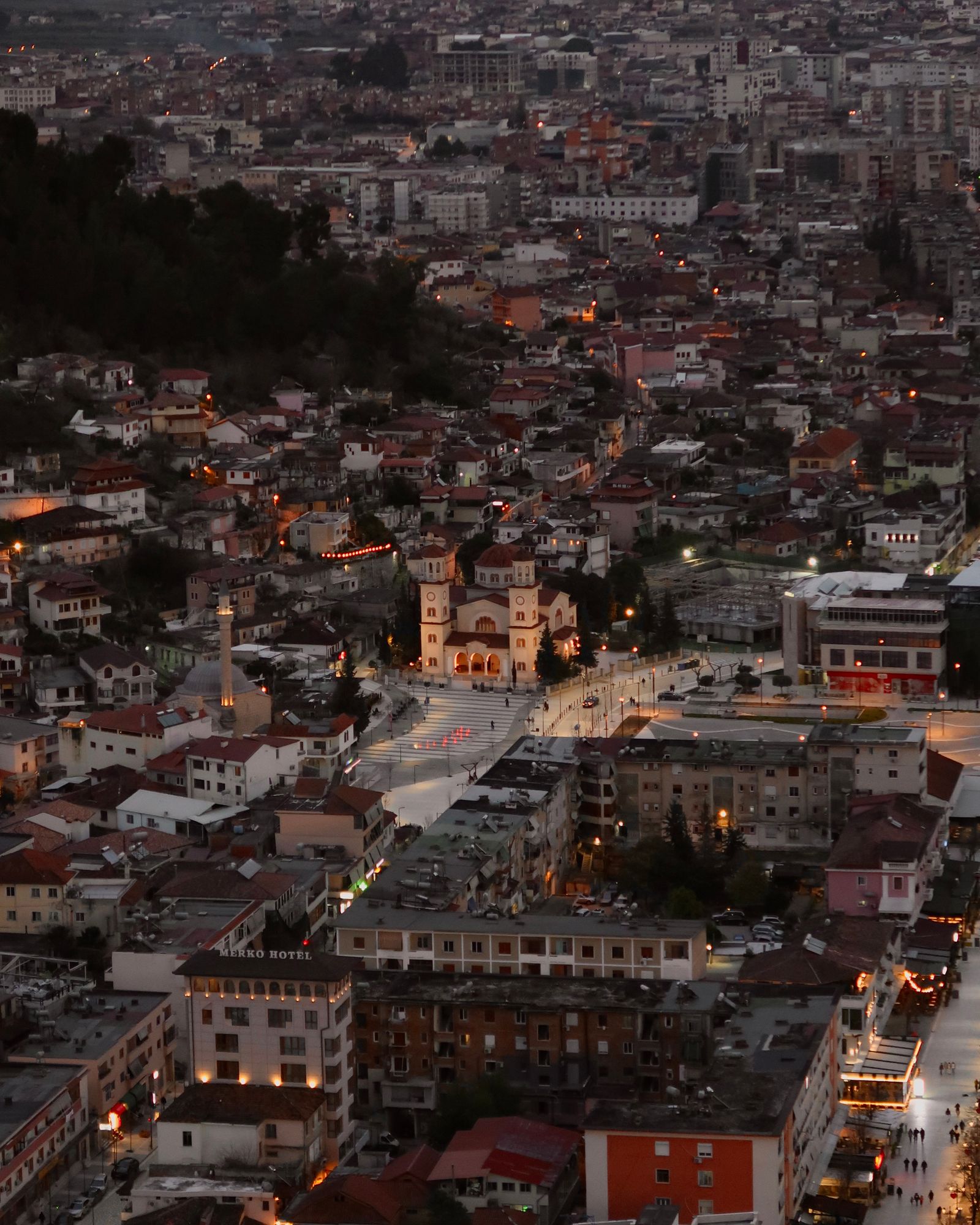 Aerial view of Berat at dusk with a historic church and hillside houses