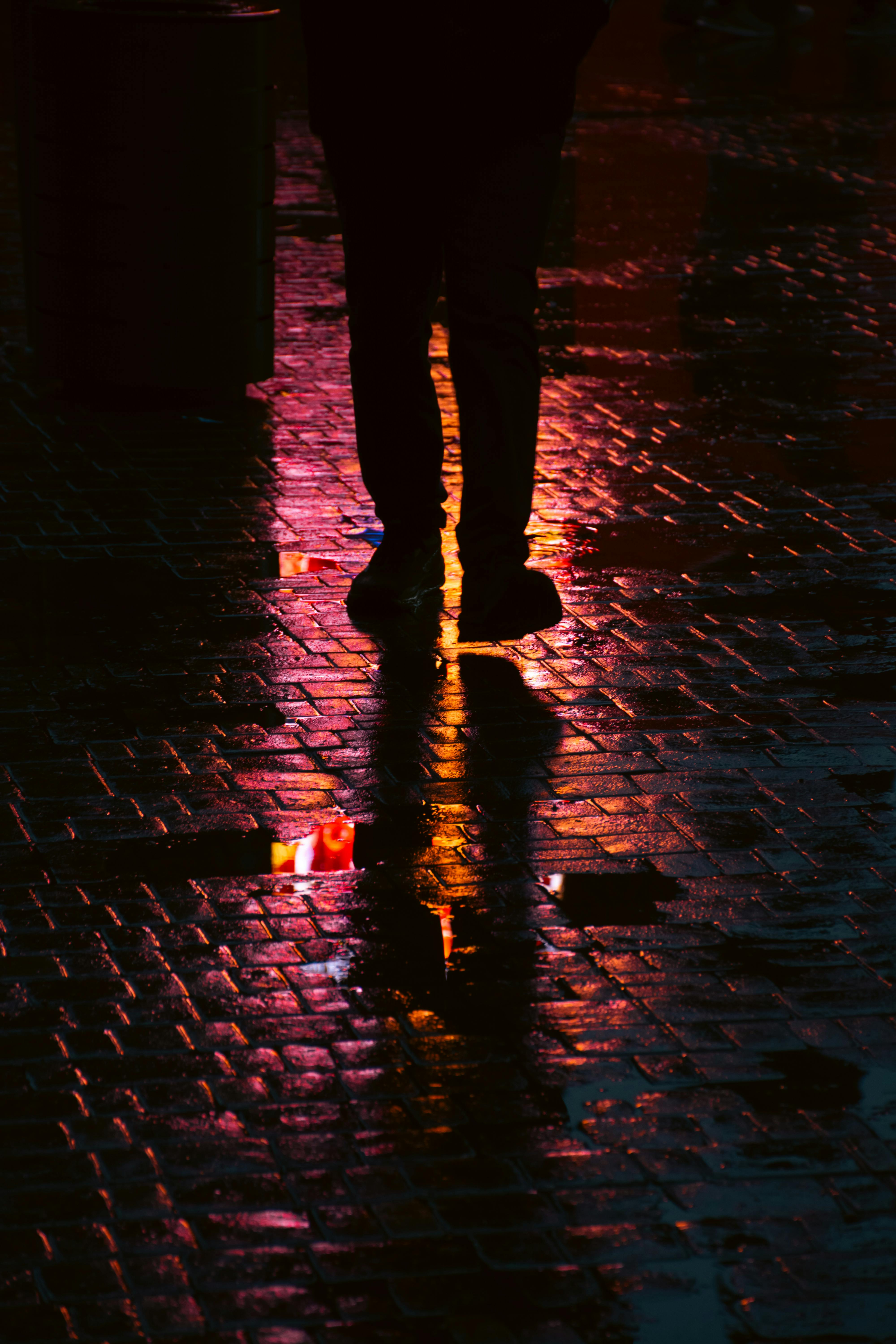 Artistic street silhouette reflecting in rain-soaked cobblestones in Baku, Azerbaijan.