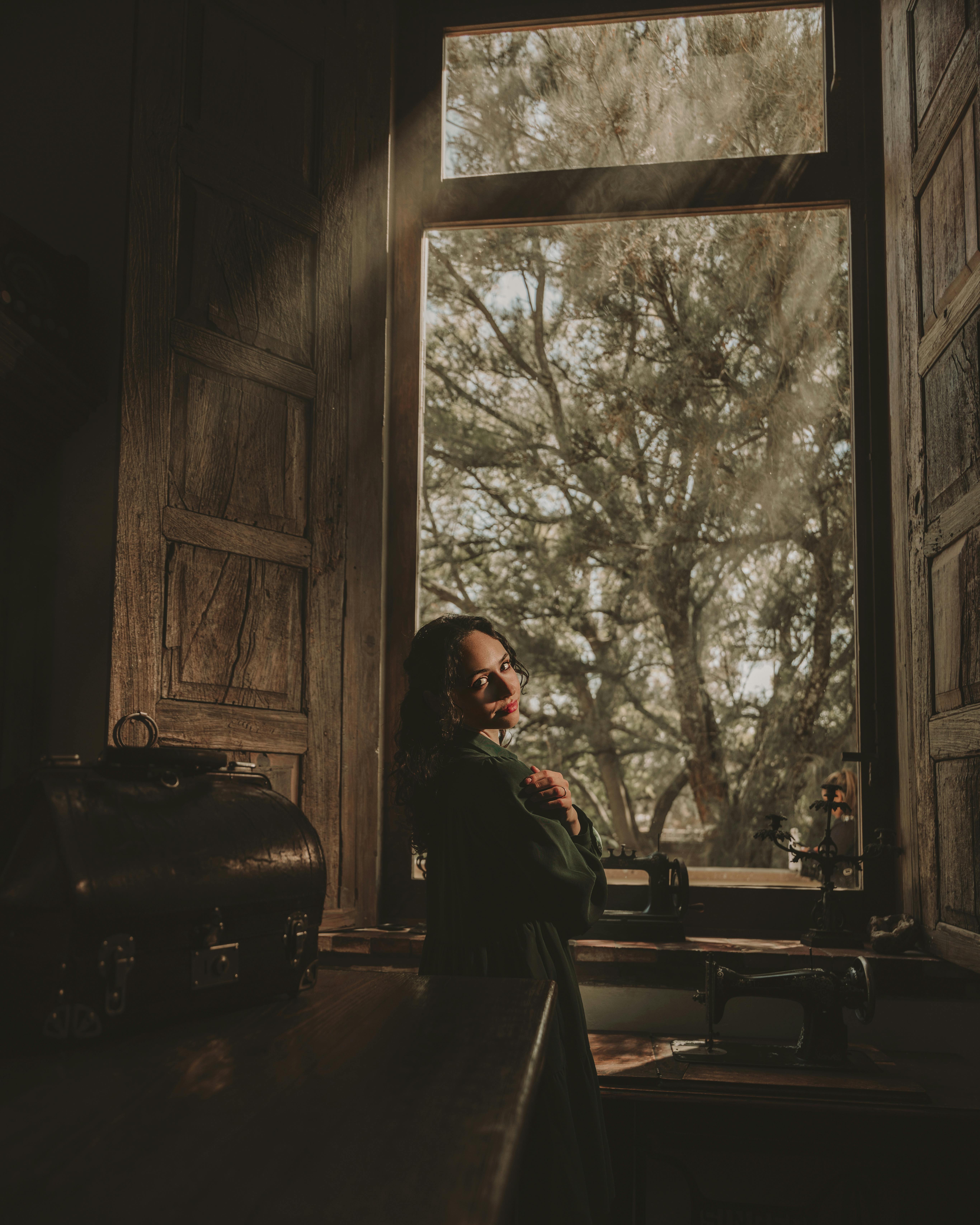 vintage woman by window with sewing machine