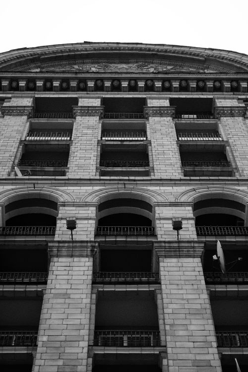 Free Black and white photo of a vintage building facade viewed from below. Stock Photo