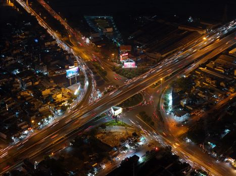 Aerial view showcasing lively traffic flow at night in a big city intersection.