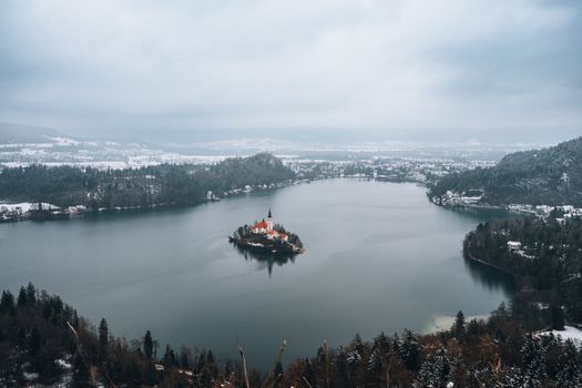 A breathtaking aerial view of snowy Lake Bled in winter with a church on an island.