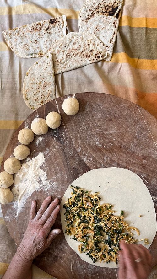 Free Hands preparing homemade flatbread with vegetable filling on a wooden board. Stock Photo