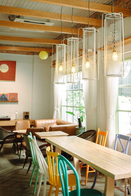 Free Warm and inviting cafe interior featuring eclectic seating and ambient lighting. Stock Photo