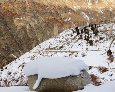Serene view of snow-covered mountains with rocky terrain in a crisp winter setting.
