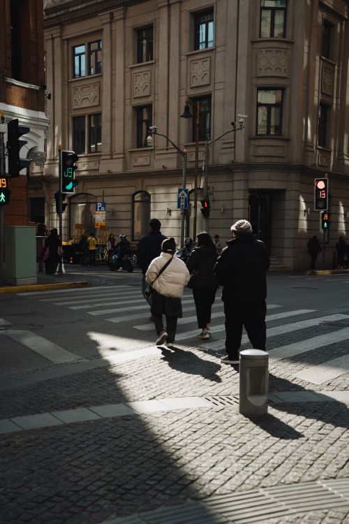 Free People crossing a busy street in Shanghai with historic architecture in the background. Stock Photo