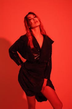 Fashion editorial portrait featuring dramatic red lighting and modern styling.