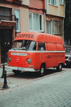 Red vintage van selling coffee parked in an Istanbul street, offering unique charm and style.