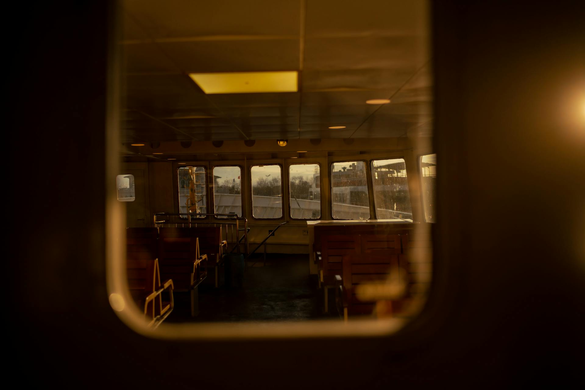 View of an empty ferry cabin illuminated by warm sunset light.