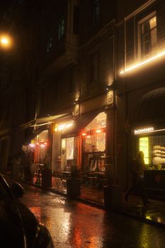 Moody night street scene with illuminated cafes in Istanbul, Turkey.