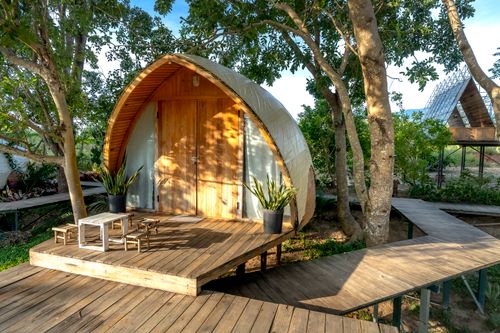 Free Charming wooden cabin with porch nestled among trees, ideal for nature retreats. Stock Photo