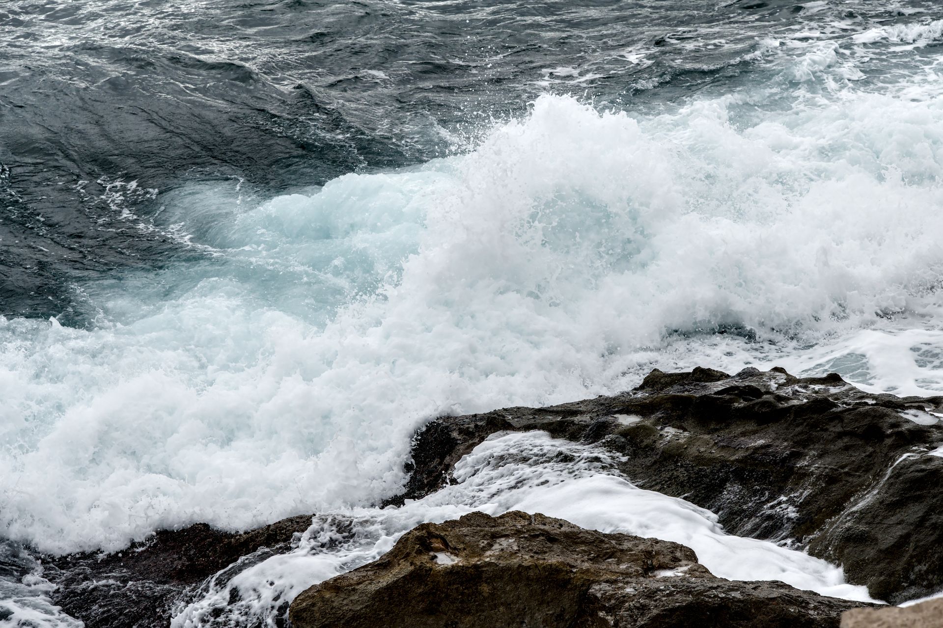 Powerful ocean waves crashing against rocky shores in Menton, France, capturing nature's raw energy.