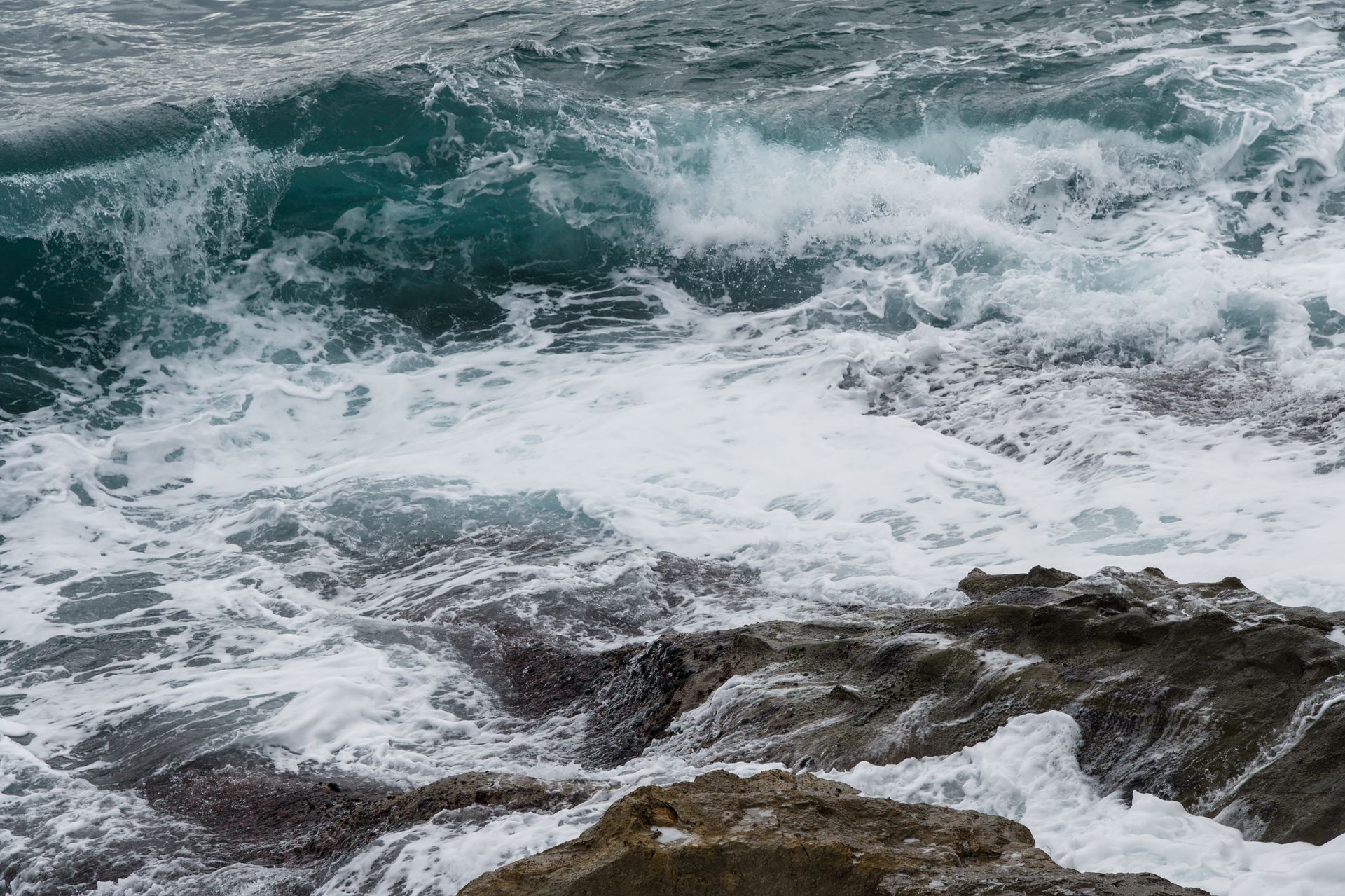 Powerful waves crash against the rocky shore in Menton, France. Captured with dynamic energy.