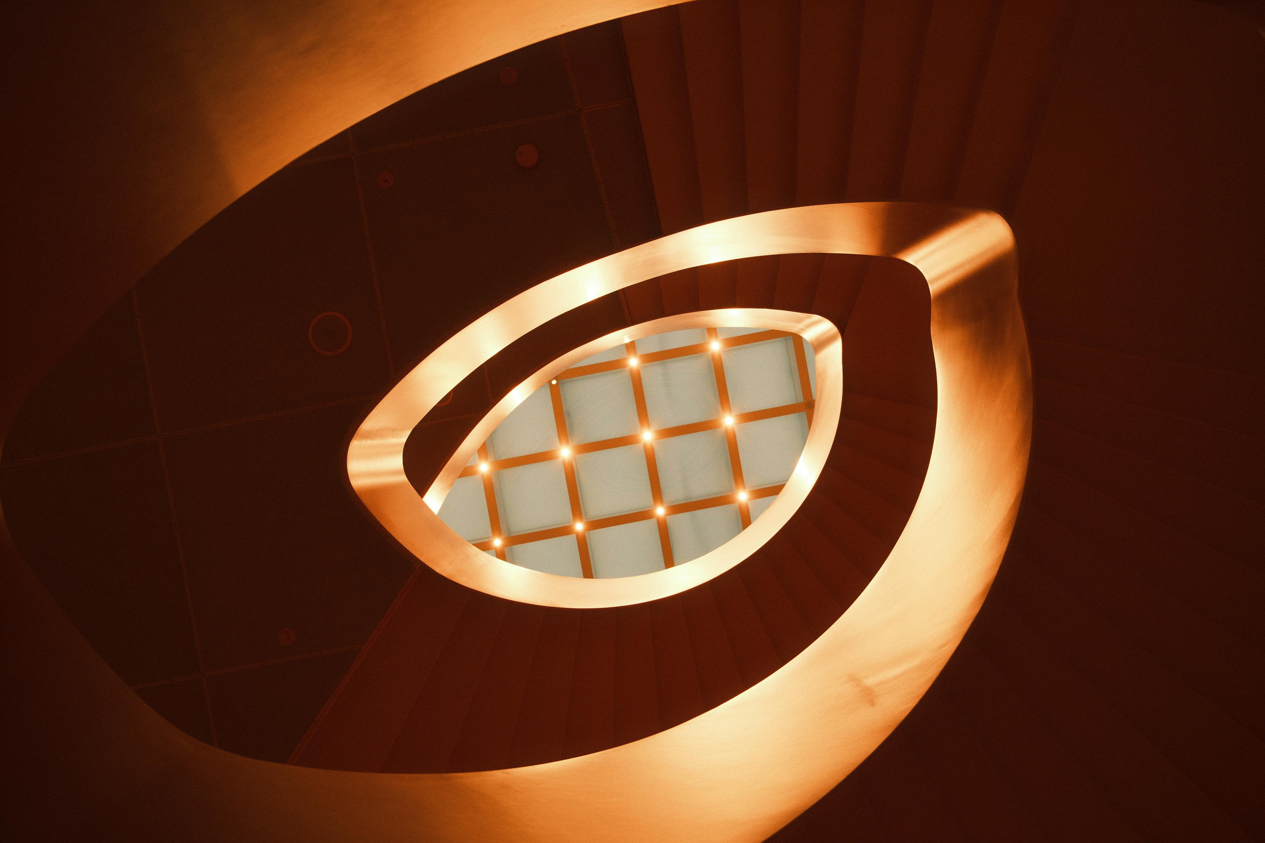 De franc Captivadora vista abstracta d'una escala de cargol amb il·luminació ambiental càlida. Foto d'estoc