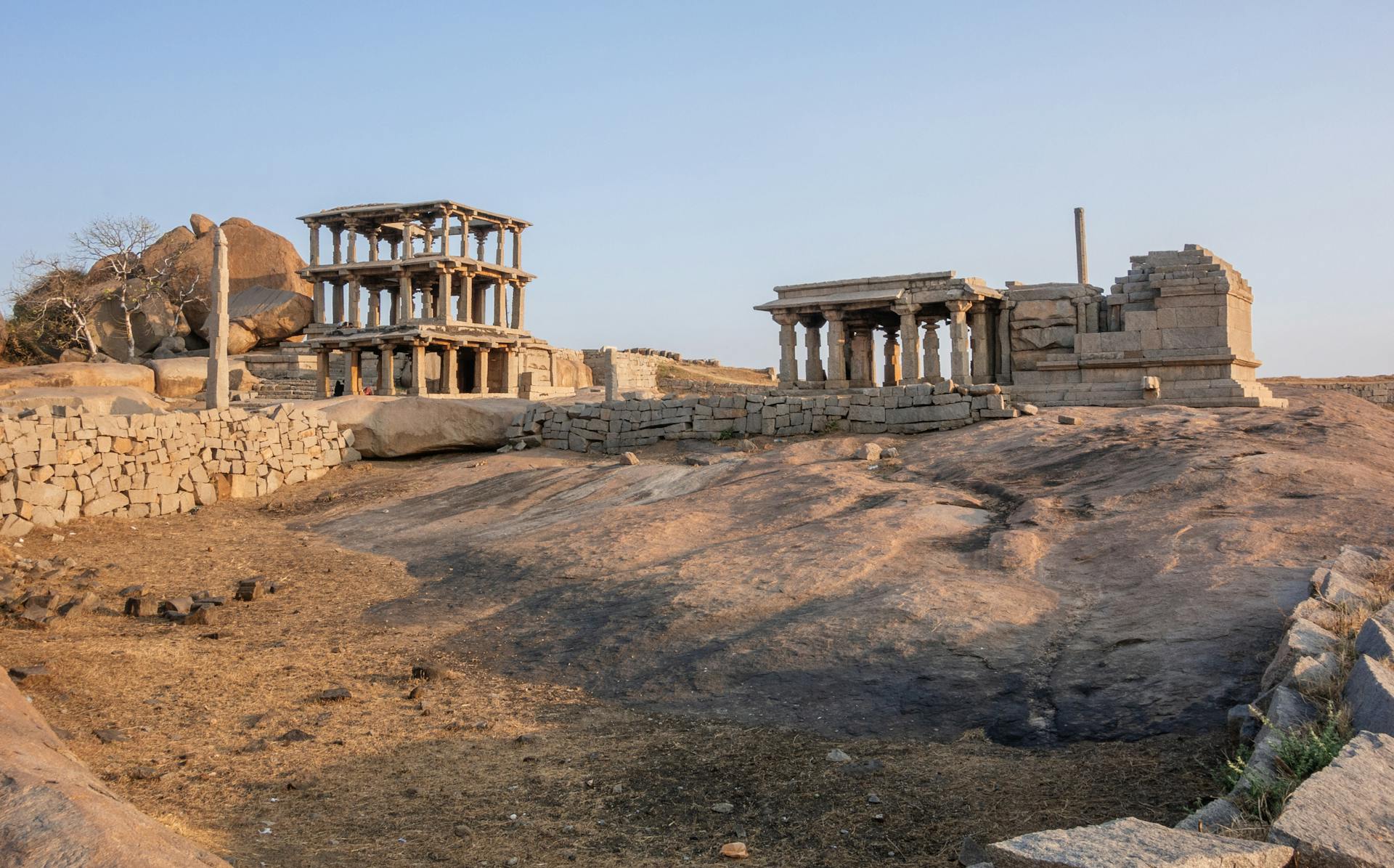 Ancient stone ruins under blue sky in Hampi, a UNESCO World Heritage Site.