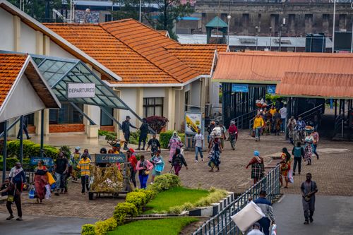 Crowds of passengers boarding minibuses and motorcycle taxis at a busy urban transport interchange in Lagos, Nigeria