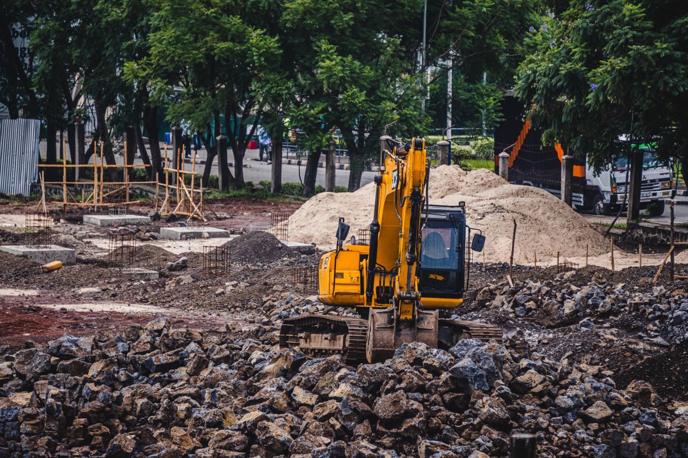 site work â€” excavator grading a commercial pad