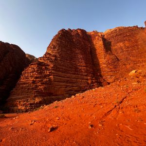 Layered red sandstone cliffs above a scree slope. Photo by Gyorgy Lakatos on Pexels
