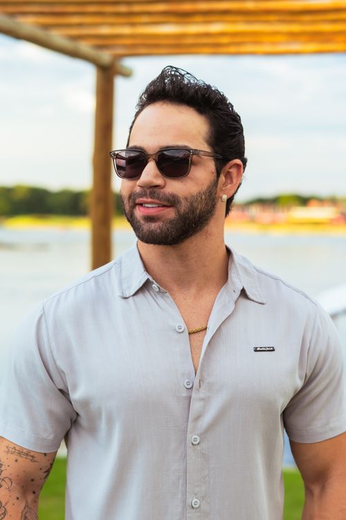 Free Stylish man in sunglasses enjoying a sunny day by the water outdoors. Stock Photo