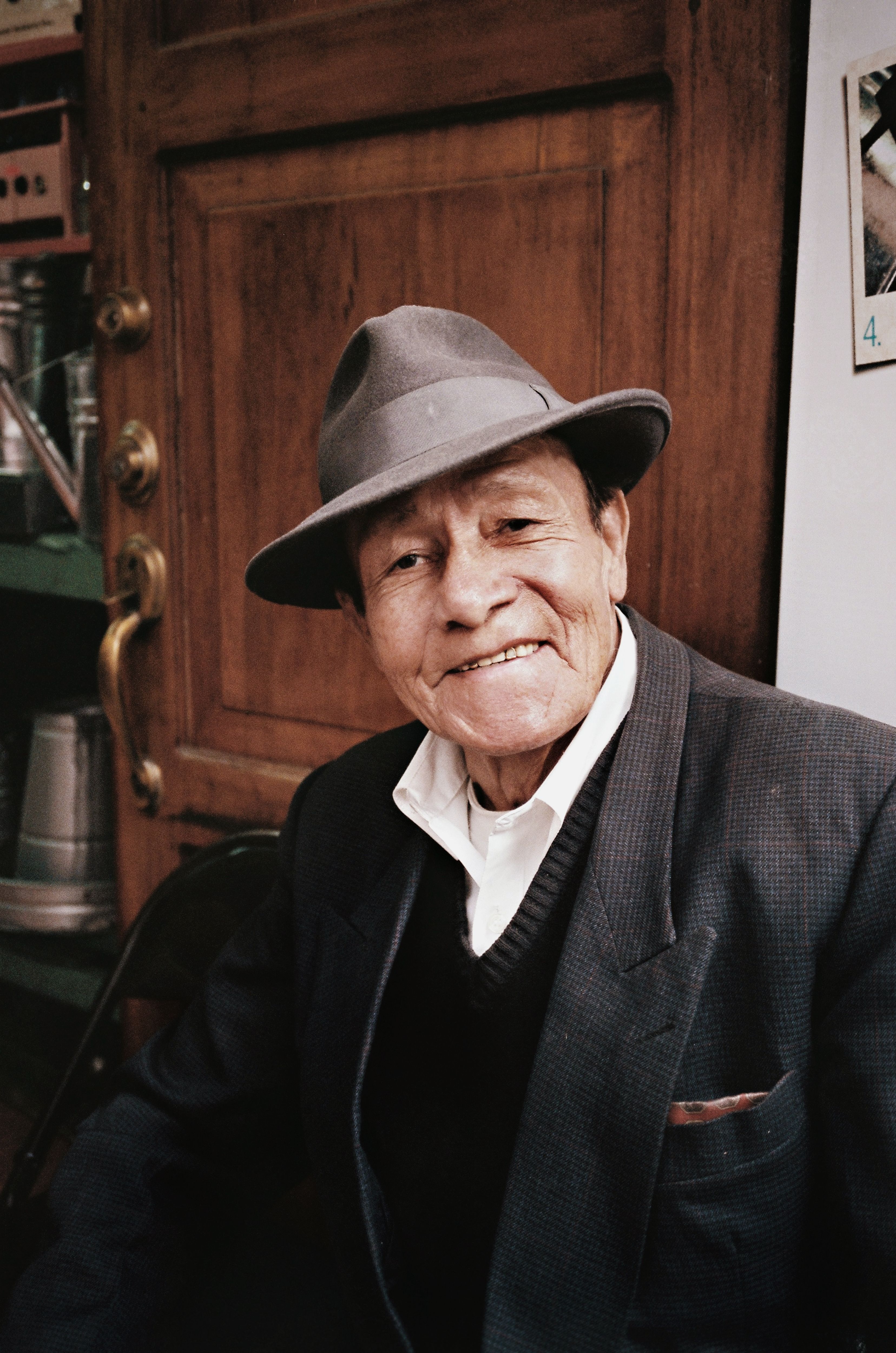Candid portrait of an Ecuadorian senior man wearing a hat and smiling warmly.