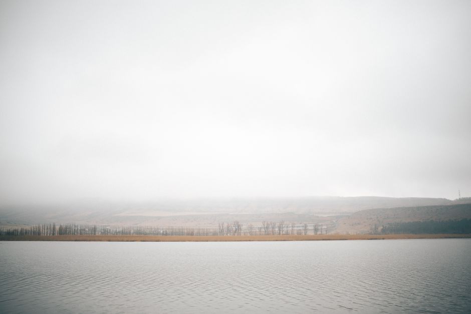 Tranquil lake and mountain landscape in Tbilisi, Georgia with overcast skies, perfect for nature lovers.